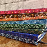 Stak of shwe shwe covered notebooks in different colour fabrics