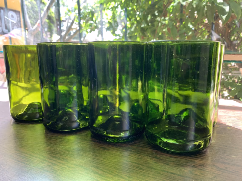 Set of four green drinking glasses made from wine bottles